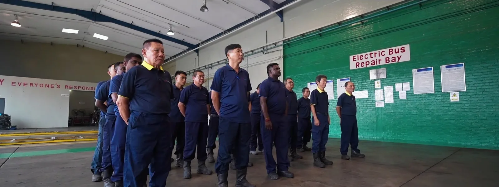 Woodlands workshop colleagues gathered in the electric bus repair bay
