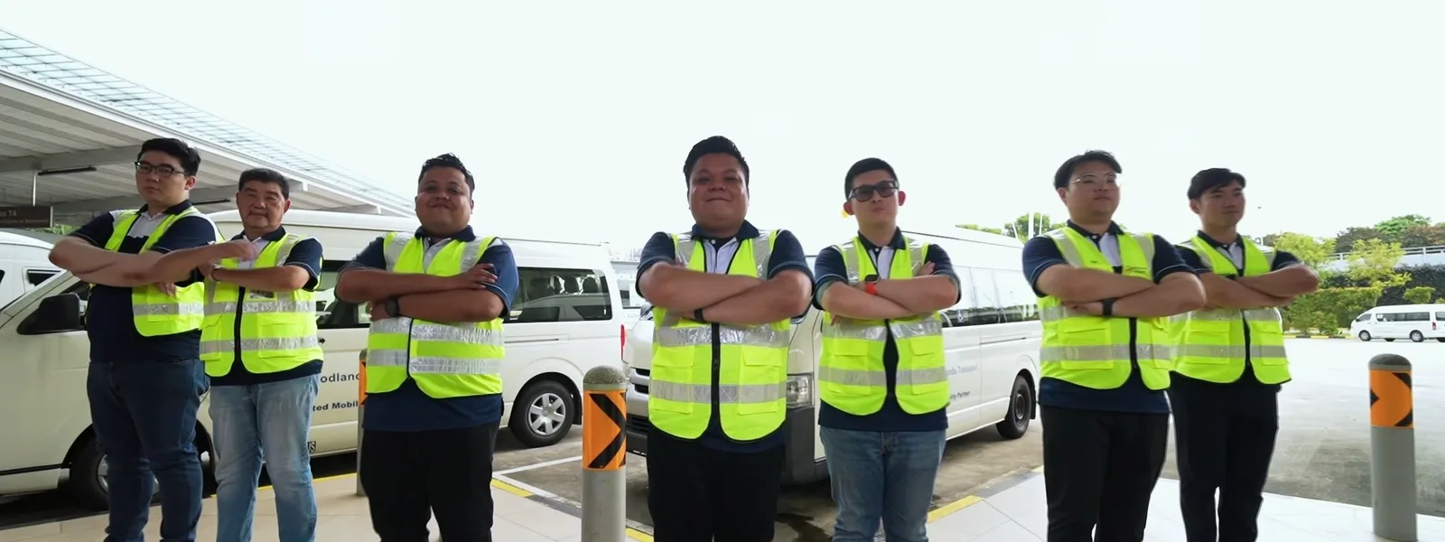 Woodlands operations colleagues in safety vests standing beside company vans