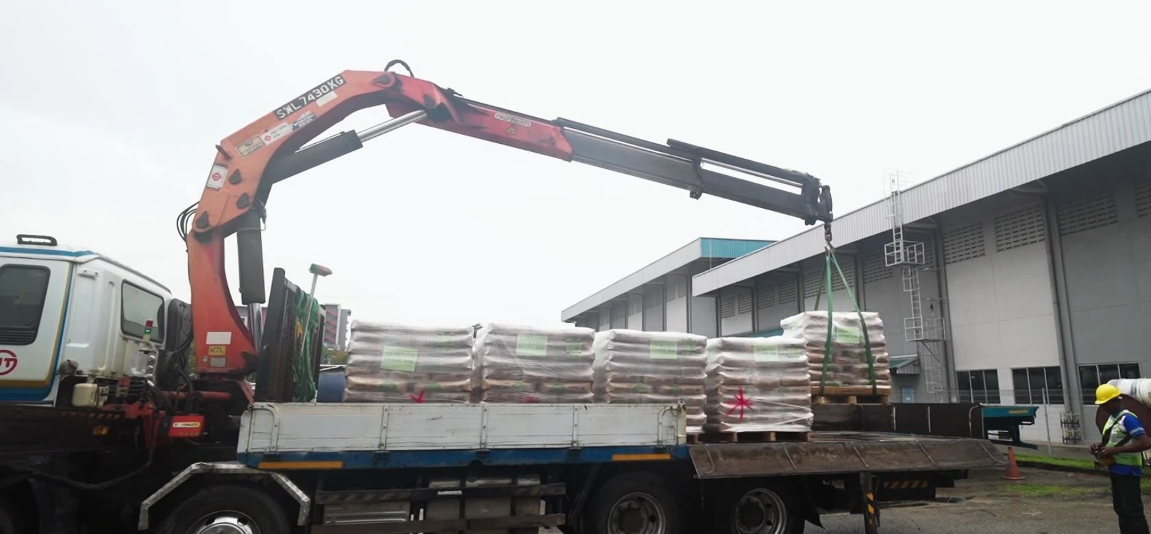 Woodlands lorry crane lifting palletised cargo in an industrial yard